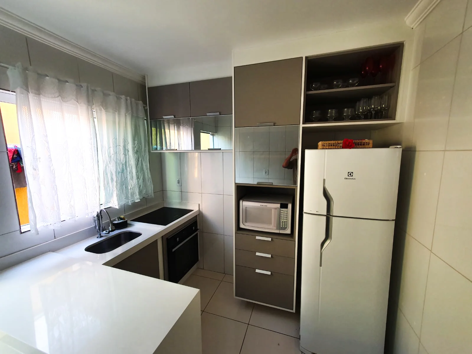 Foto de cozinha planejada com ênfase nos tons branco e marrom